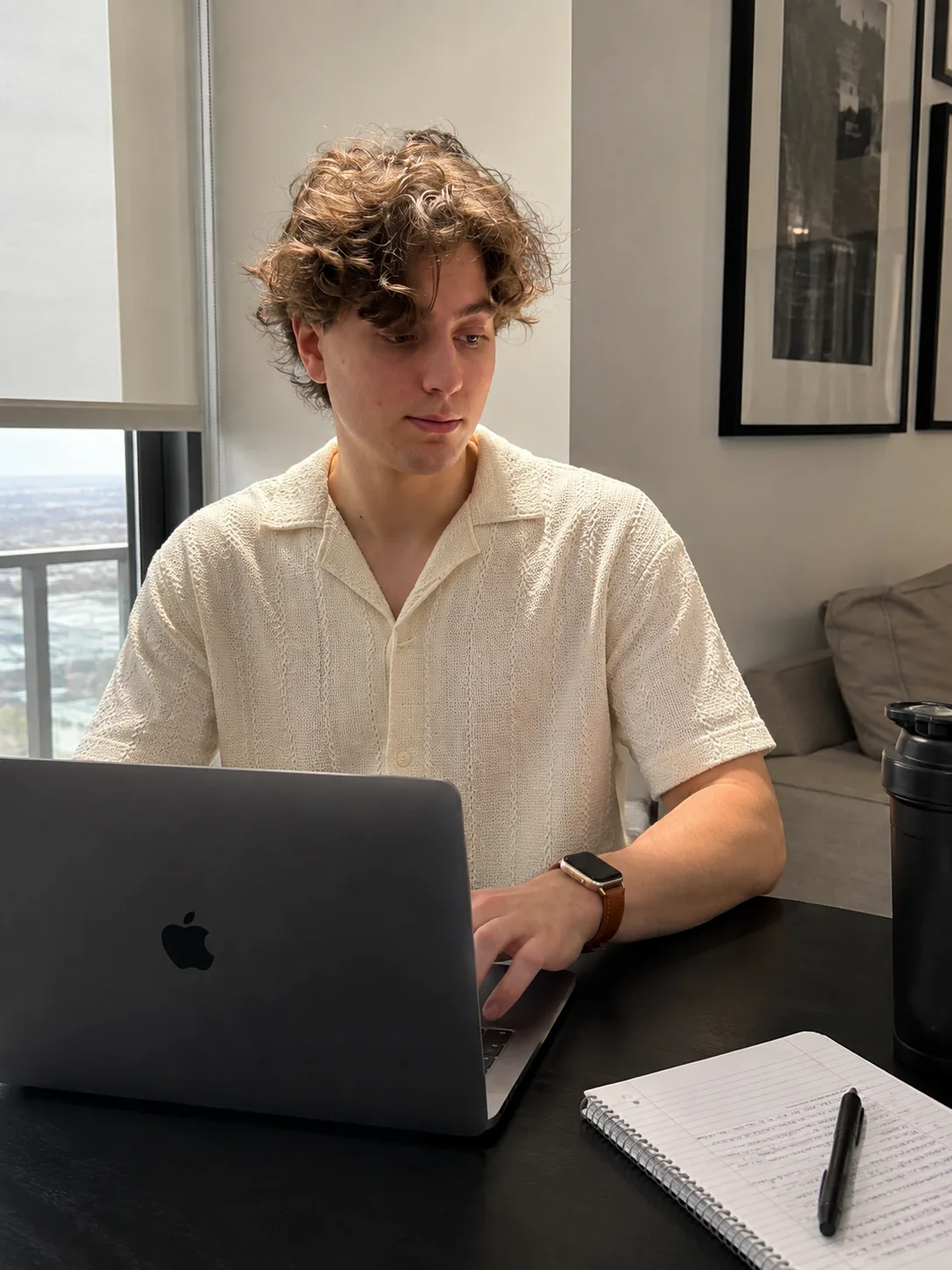 Adam Rockensuess working at a laptop by a window